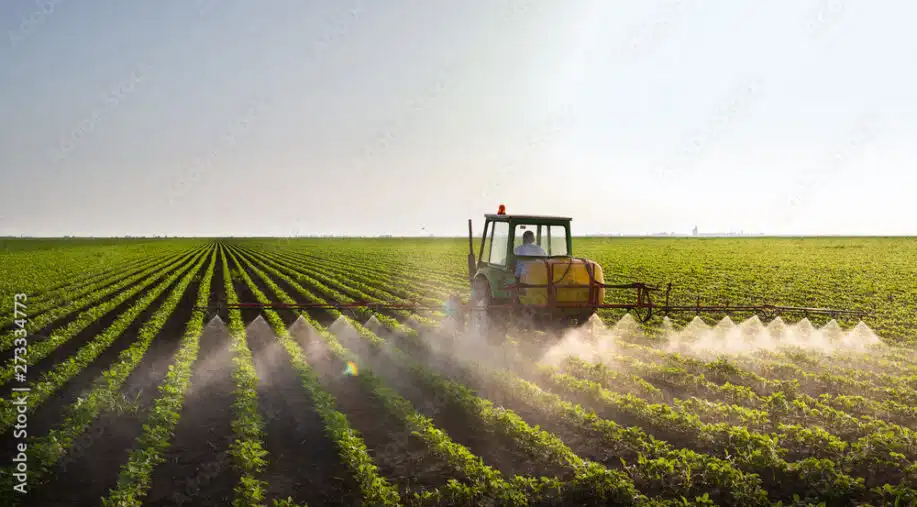 Tractor spraying soybean field